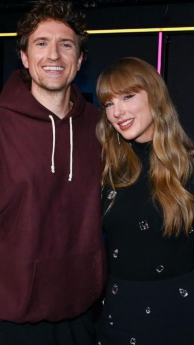 Greg James and Taylor Swift in the Radio 1 studio smiling next to each other