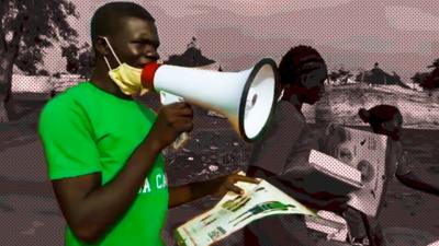 Man with loudhailer holding public health poster