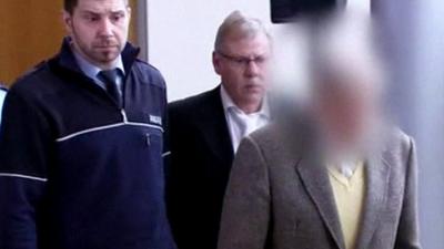 Reinhold Hanning, his identity concealed, arrives in court