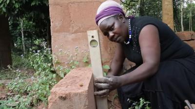 Jane Ifeoma measuring a brick