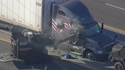 Armoured vehicle tears open lorry door