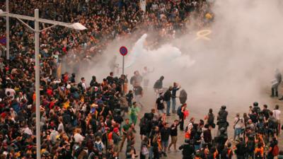 Huge crowd of protesters confronted by police officers with gas