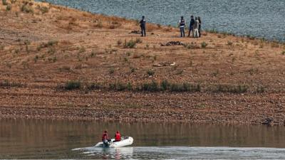 Police on land and police in a boat