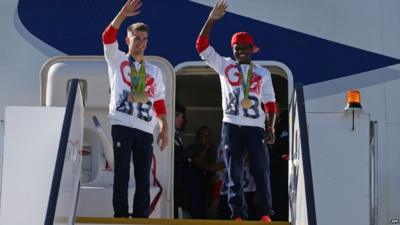 Gymnast Max Whitlock and Nicola Adams wave from the top of the aircraft steps