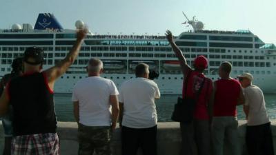 Cubans wave at the Adonia