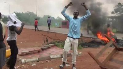 A protester in front of a fire