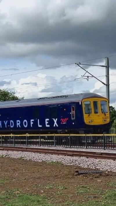 A purple train with yellow front on a test track