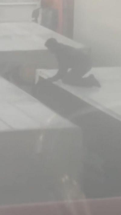 Man on top of lorry with other lorries surrounding it in foggy conditions