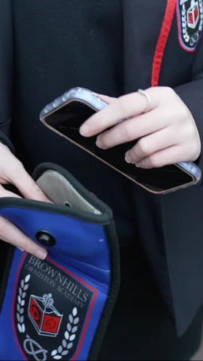 A close-up of a mobile phone being placed into a blue pouch