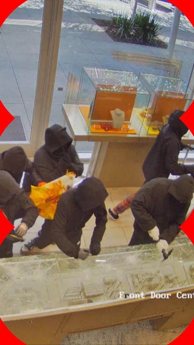 Robbers dressed in black smash jewellery cases with hammers 