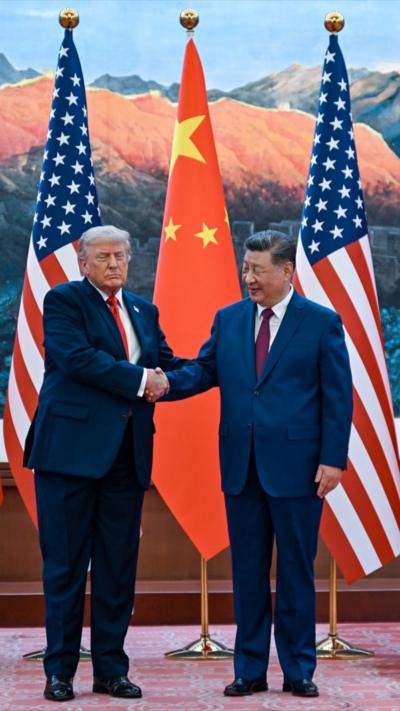 Trump and Xi shake hands and pose for photos in front of China and US flags. 