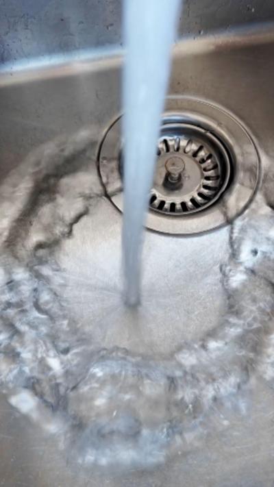 Water pouring into a metal sink. 