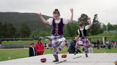 two girls dancing around swords