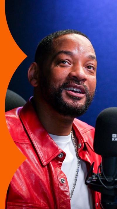 Will Smith, wearing a red leather jacket, in the Radio 1Xtra studio