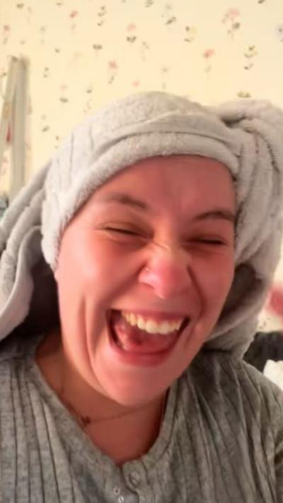 a woman laughing with a towel round her head