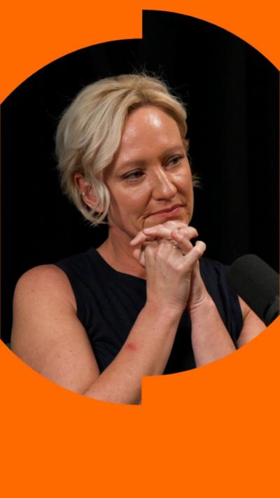 Ruth Dodsworth clasps her hands together by her chin. She is wearing a black sleeveless top and looking to her left.