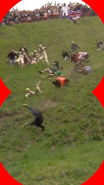 People run, roll and fall down a steep hill as crowds watch