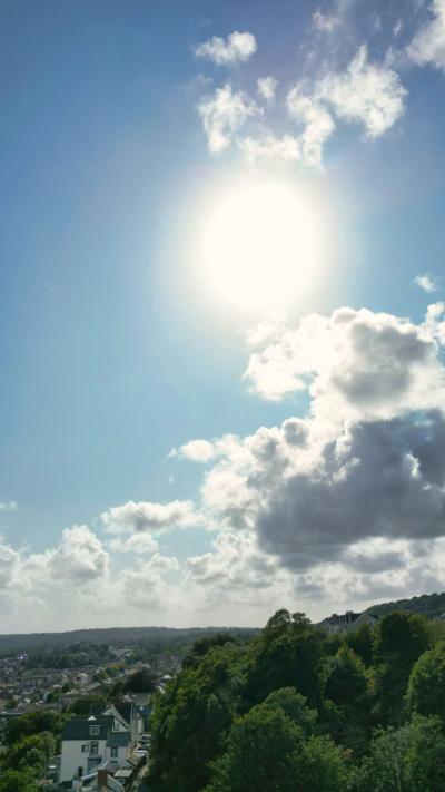The sun shining in the sky above green fields