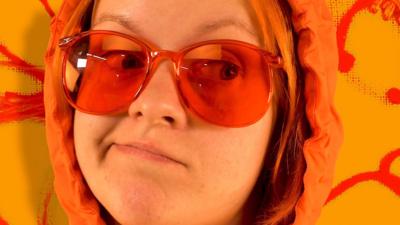 Close up of Eleana Re wearing red-lensed glasses