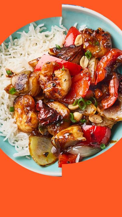 An aerial shot of kung pao prawns, vegetables and white rice  on a blue plate 