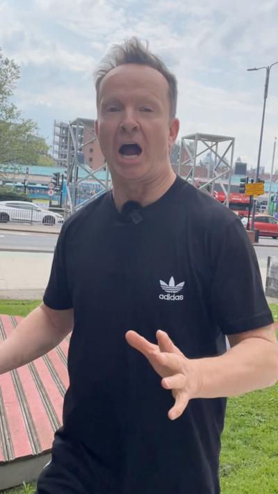 BBC weather presenter Paul Hudson runs along a path wearing black running gear.