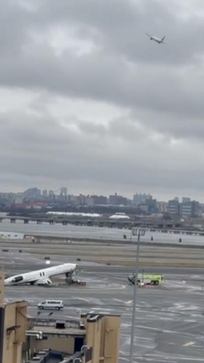 A plane takes off into a leaden grey with the wreckage of a plane below. 