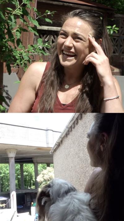 Woman with long brown hair sat in garden with flyover behind her