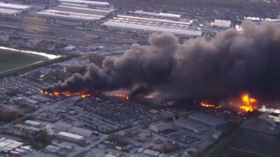 A long plume of smoke rises from Louisville, Kentucky over tens of buildings.