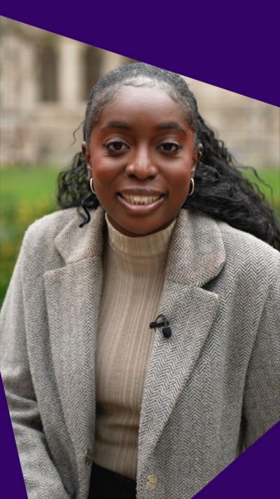 BBC's Jonelle Awomoyi smiles to the camera wearing a beige top and a grey coat.
