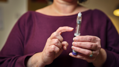 A woman holding a weight-loss jab