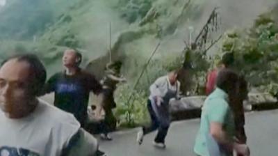 People seen running from a landslide is triggered by heavy rain in southern China