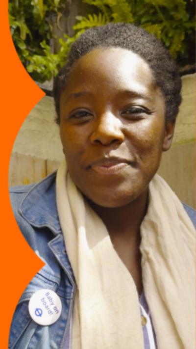 Kimberley Wilson wears a blue denim jacket and a cream scarf. She's wearing a badge that reads "Baby on board".