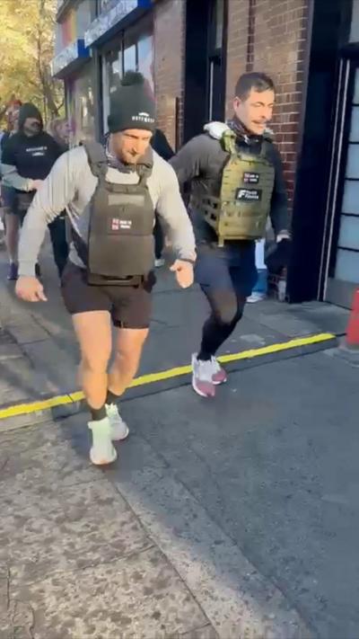 Two men run on a street.