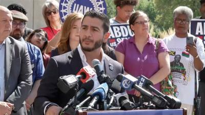 Abdul El-Sayed speaks into mics.
