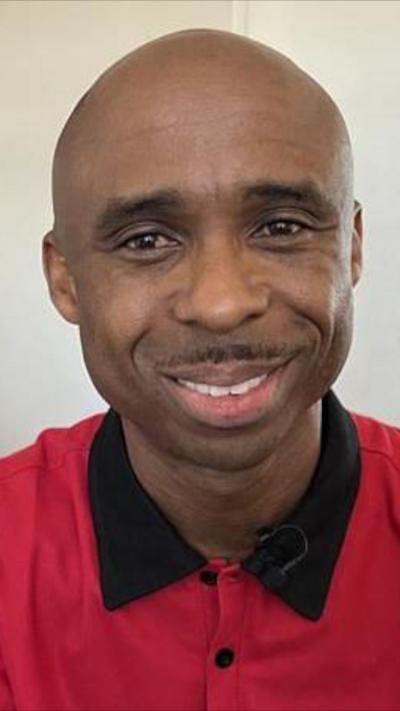 Bald man with beard smiling and wearing red shirt 