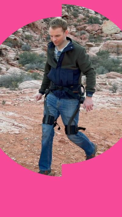 A man wears an exoskeleton in an arid landscape