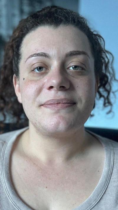 A woman with black hair looking towards the camera.