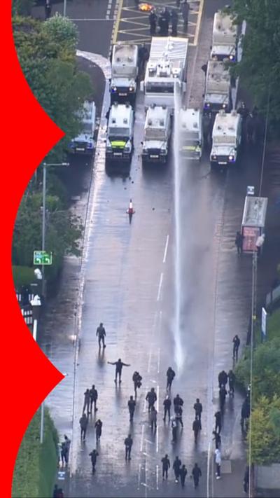 Protesters being sprayed with water canon