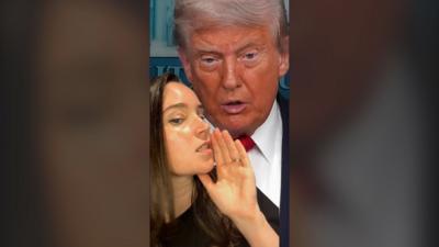 A woman, Lizzy McNeill, holds her hand to her mouth in front of a picture of Donald Trump
