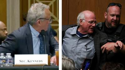 On right side, RFK Jr standing up. On left side, Ben Cohen being removed by police