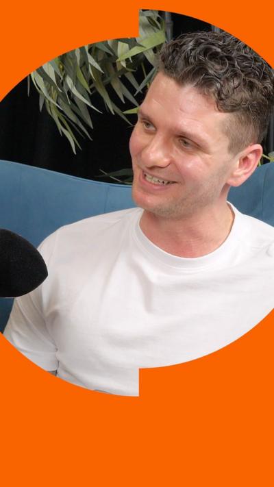 A man with gelled hair wearing a white t-shirt