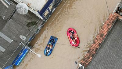 People in inflatable rafts floating on flood water