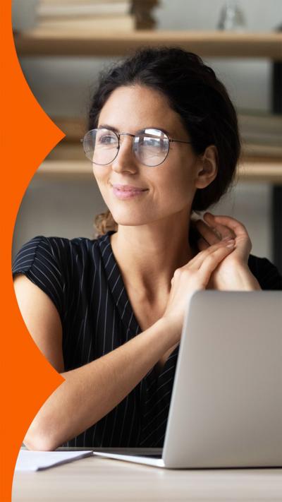 A woman sitting in front of her laptop, smiling