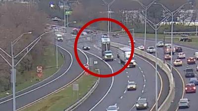 A truck can be seen hitting an overhead sign, circled in red.