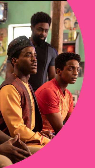 Men sit in line in a barbershop, in the centre is the Doctor played by Ncuti Gatwa