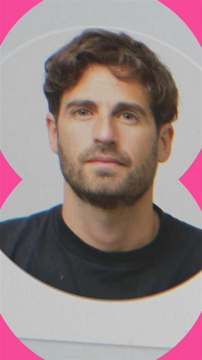 A profile photo of a man with short brown hair and stubble