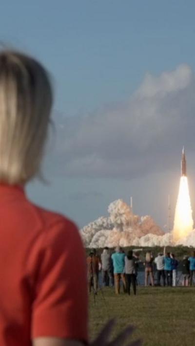 A BBC anchor looks at the Artemis II rocket launching