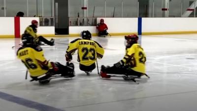 Three para-ice hockey players about to collide