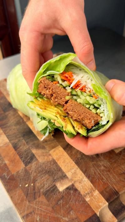 Craig Morison holding his dish of a giant summer roll, it's open so you can see all of the fillings