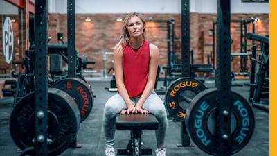 Woman in the gym sitting on a bench